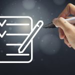 Gros plan sur une main avec un feutre qui dessine une liste
