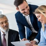 Photo de 2 hommes et une femme dans un bureau qui regardent une tablette