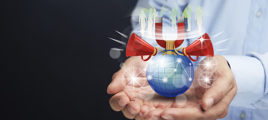 Gros plan sur des mains qui tiennent un globe sur lequel sont posés des mégaphones