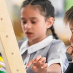 Deux jeunes enfants jouent avec un boulier coloré