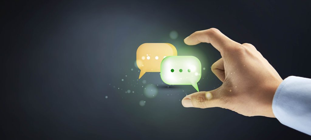 Gros plan sur une main qui tient deux bulles de conversation