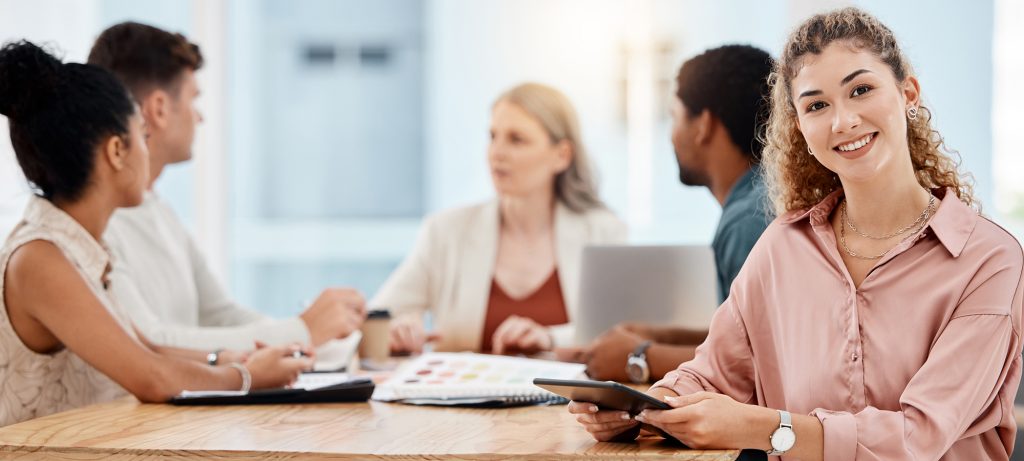 Trois femmes et deux hommes autour d'une table de conférence
