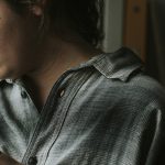 Une jeune fille regarde tristement par la fenêtre