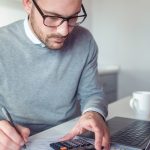 Un homme effectue utilise une calculatrice