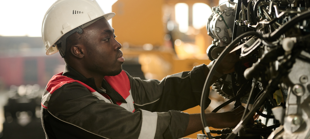 Un homme portant un casque de sécurité manipule un équipement hydraulique