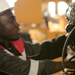 Un homme portant un casque de sécurité manipule un équipement hydraulique
