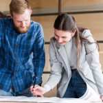 Un homme et une femme penchés au dessus d'un plan
