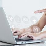 Une main pointe vers l'écran d'un portable