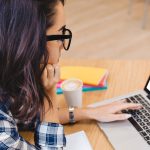 Une jeune femme regarde un écran où se trouve le logo de PoerPoint