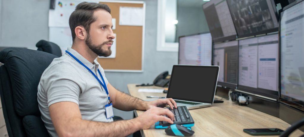 Un homme tape au clavier devant un ordinateur