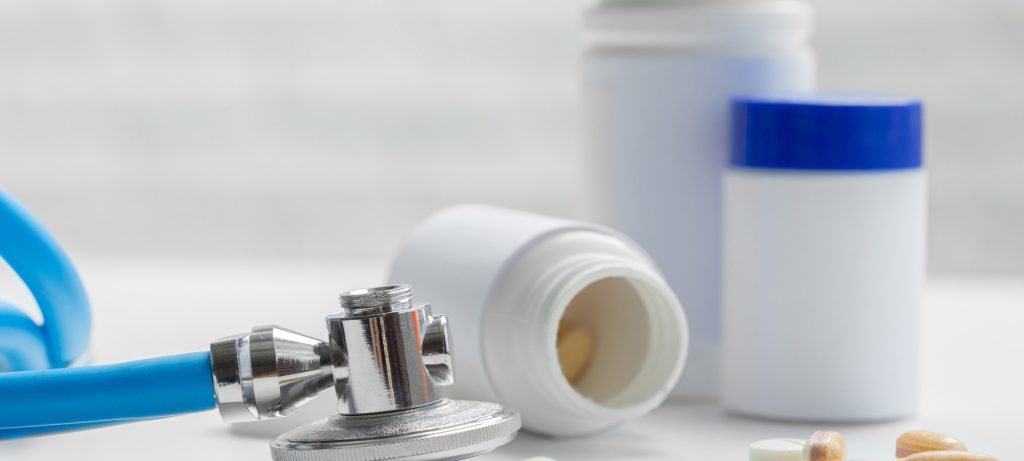 un stéthoscope et des contenants de comprimées