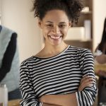 Une jeune femme en avant-plan devant une équipe de 4 personnes