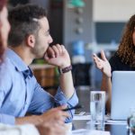 Trois personnes en réunion autour d'une table de conférence