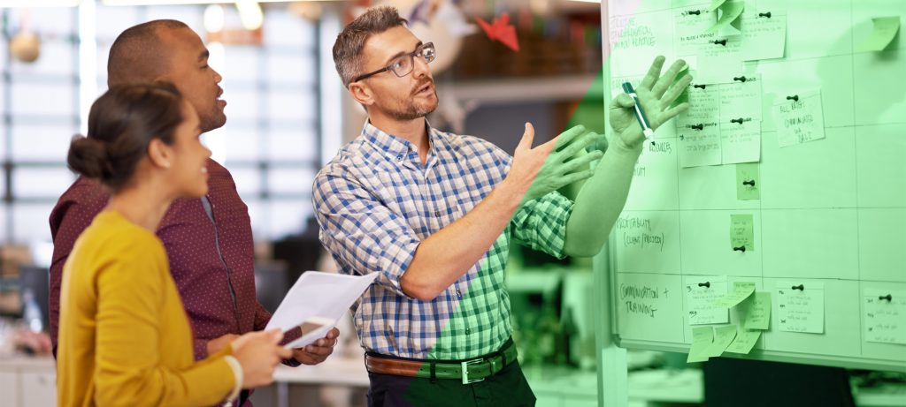 Trois personnes devant un tableau de production