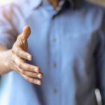 Personne en avant plan présentant sa main droite